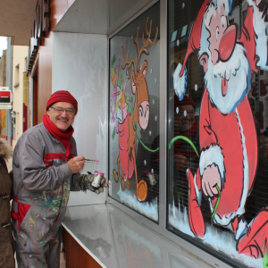 Jean-Marie et Martine Lesage devant une vitrine peinte en France