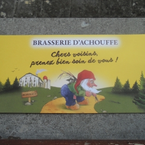 Le nuton emblème de la Brasserie d'Achouffe. À l'arrière-plan, la brasserie.