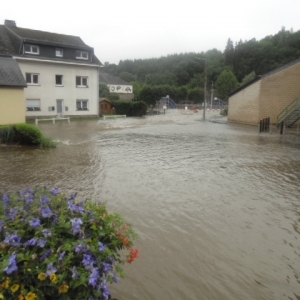 Les Quatre Bras près du hall polyvalent: de la Cour de l'abbaye, du parking le long de la rivière, de l'espace entre le pont et le hall, et de la voie vers les équipements de plein air