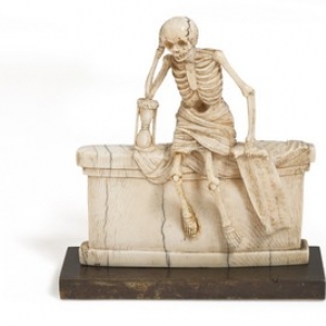 squelette dans un linceul assis sur un tombeau