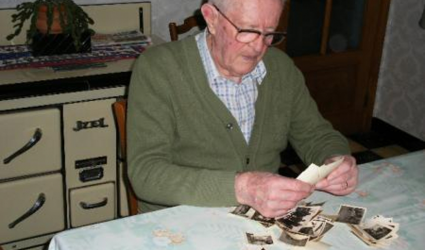 Un ancien Prisonnier de Guerre houffalois regarde les photos de ses souvenirs