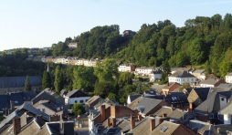 Le Thier des Cochons, au-delà de la crête de feuillus dominant la rue escarpée du Bois des Moines, ancienne route de Liège.