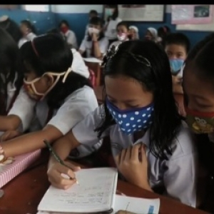 A Singapour, des enfants se protegent de la fumee toxique qui emane de l incendie des forets