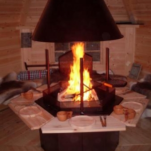 le tres convivial kota gril amenage de facon agreable - les convives sont assis sur des peaux de rennes et peuvent deguster leur delicieux barbecue dans des assiettes en bois d'aulne ,des tasses et couverts en bois 